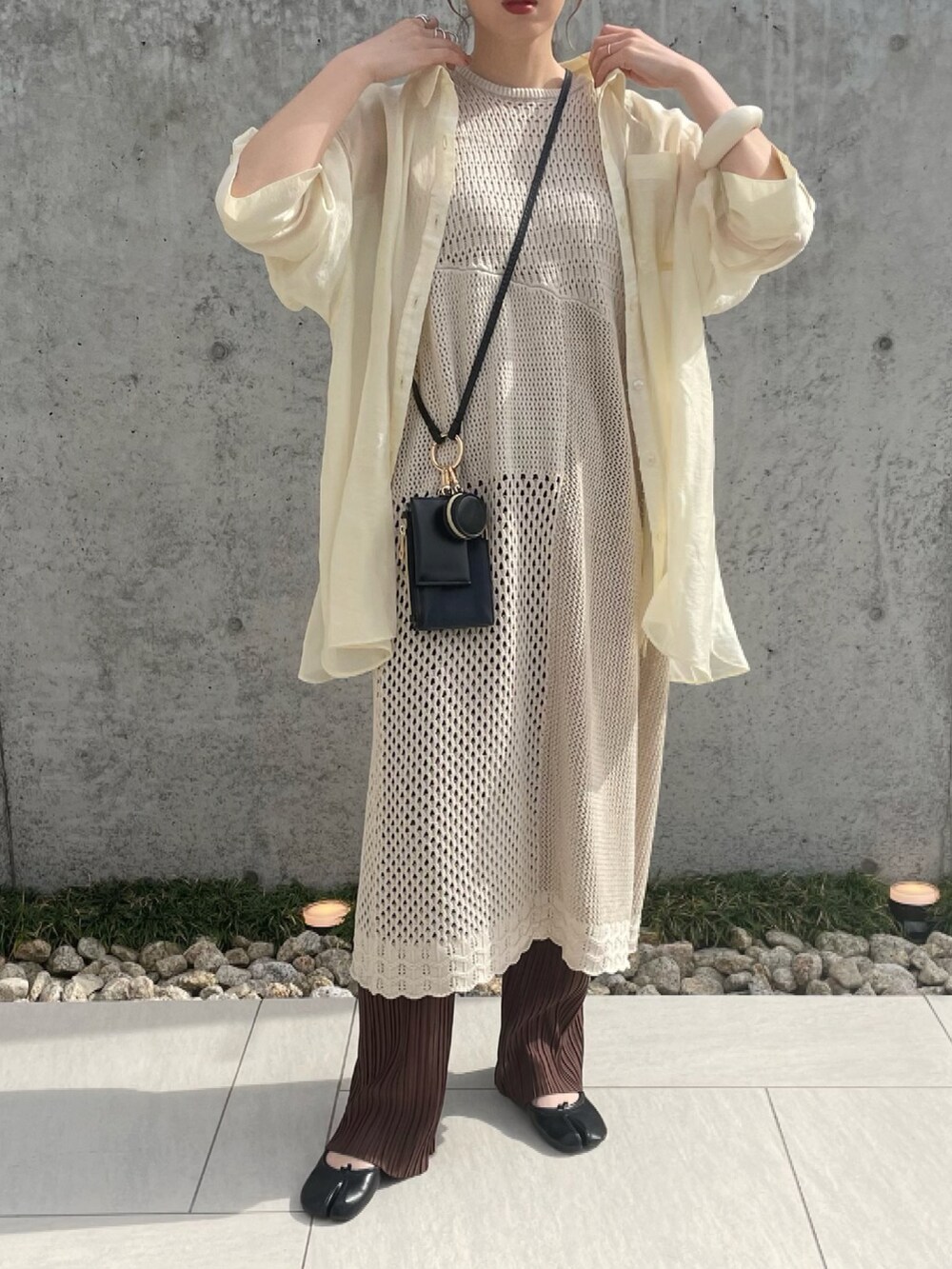 ホワイト系のニット/セーター、ブラック系のショルダーバッグ、ブラック系のパンプスを着用したレディースの春コーディネートの2枚目の写真