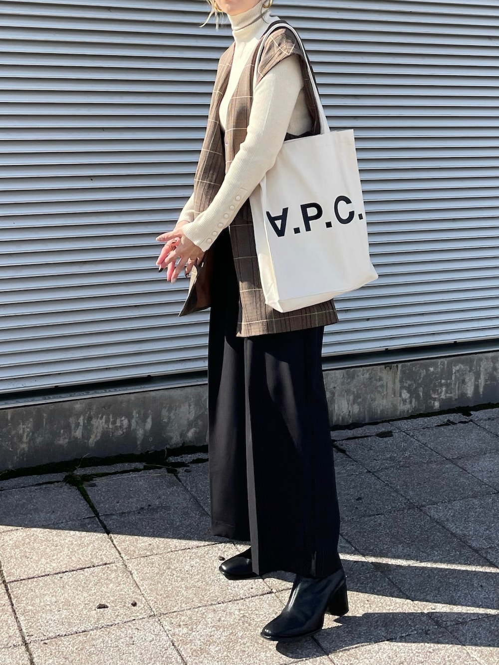 ホワイト系のニット/セーター、ホワイト系のトートバッグ、その他のベストを着用したレディースの冬コーディネートの2枚目の写真