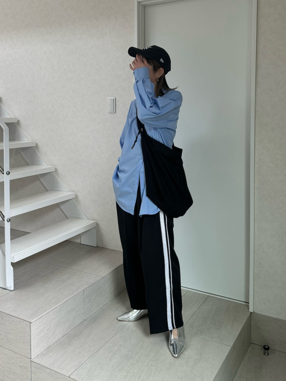 ブルー系のシャツ/ブラウス、ブラック系のスラックス、シルバー系のパンプスを着用したレディースの冬コーディネートの3枚目の写真