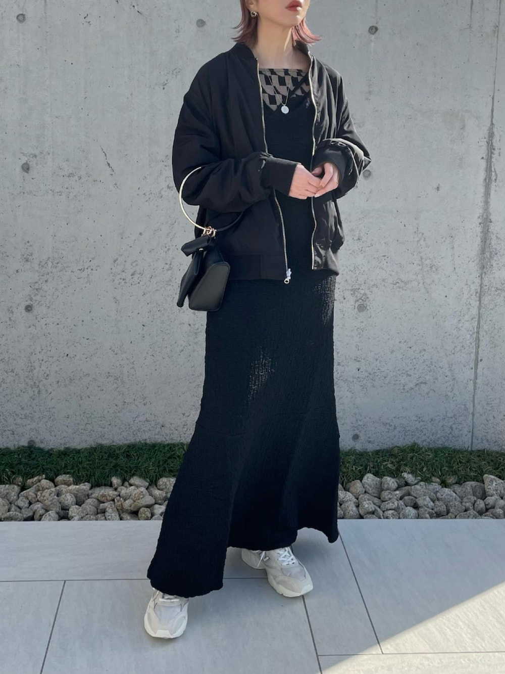 グリーン系のMA-1、ブラウン系のキャミソール、ブラック系のワンピースを着用したレディースの春コーディネートの2枚目の写真