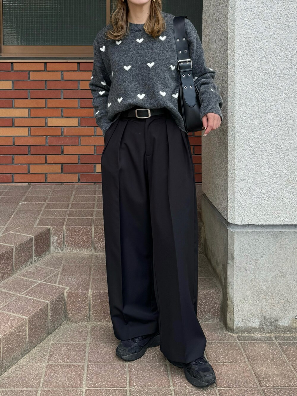 グレー系のニット/セーター、ブラック系のハンドバッグ、ブラック系のその他パンツを着用したレディースの秋コーディネートの3枚目の写真
