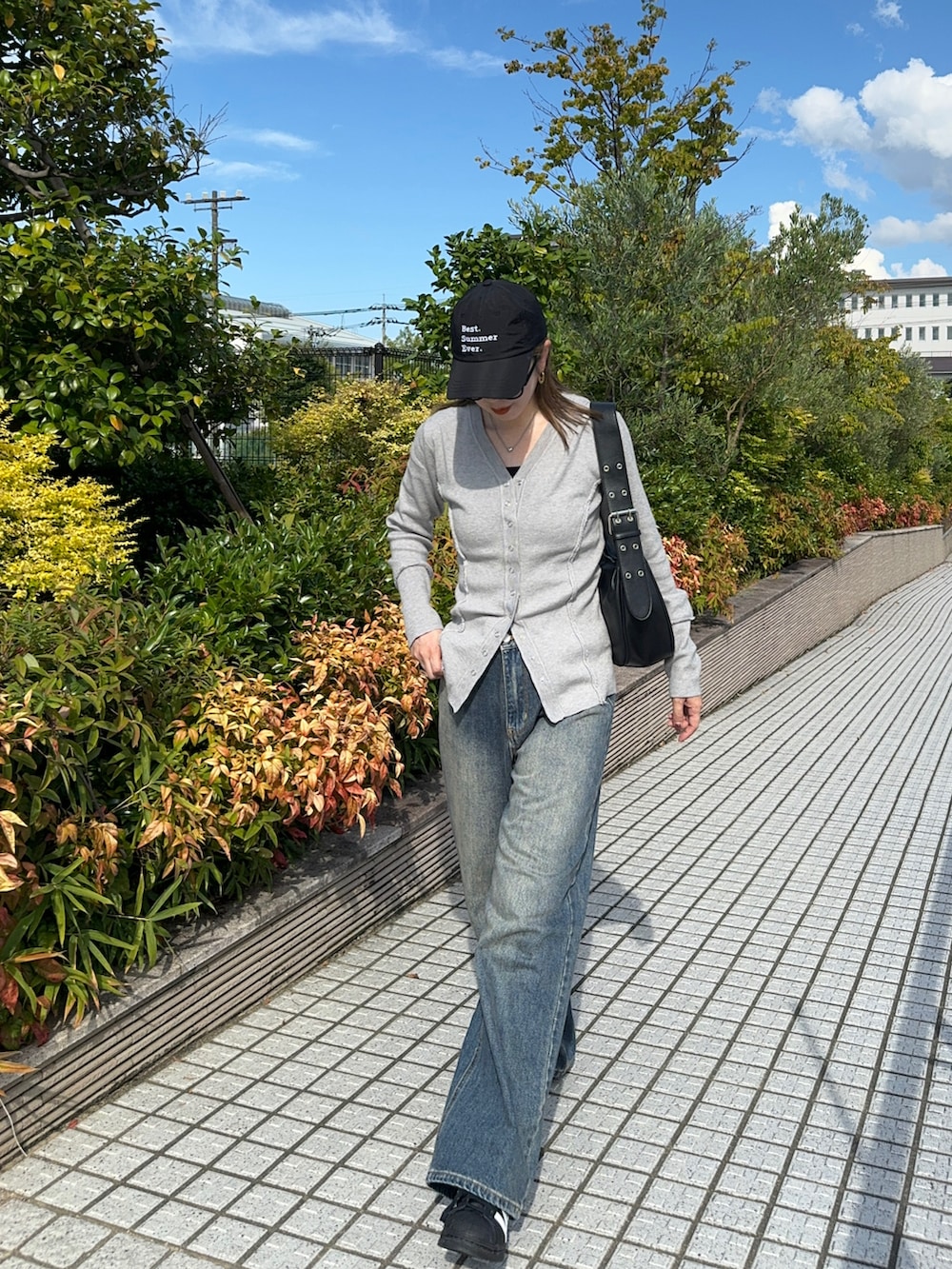 グレー系のカーディガン/ボレロ、ブルー系のデニムパンツ、ブラック系のハンドバッグを着用したレディースの夏コーディネートの3枚目の写真