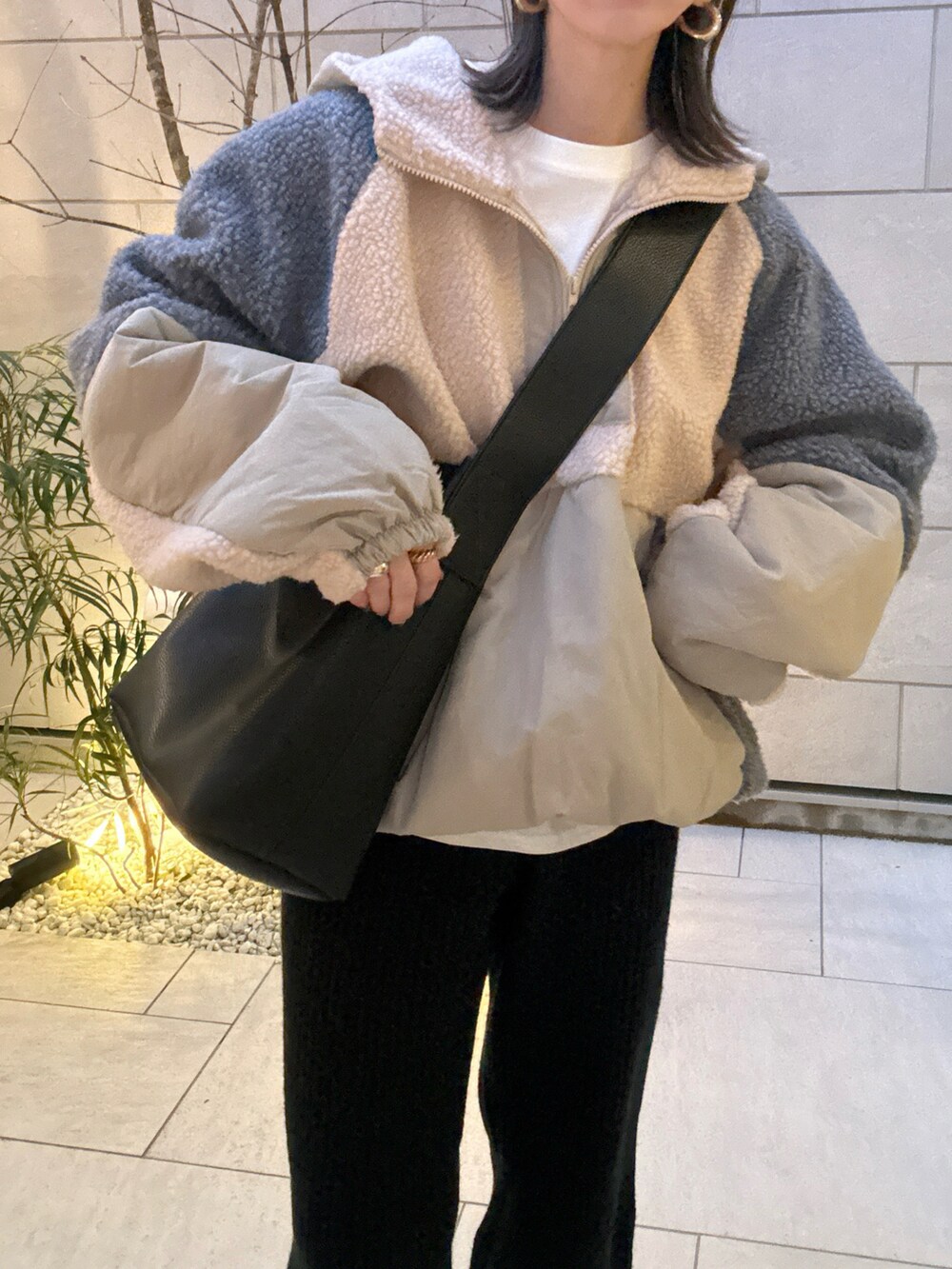 ベージュ系のブルゾン、ブラック系のショルダーバッグ、ブラック系のスニーカーを着用したレディースの冬コーディネートの4枚目の写真