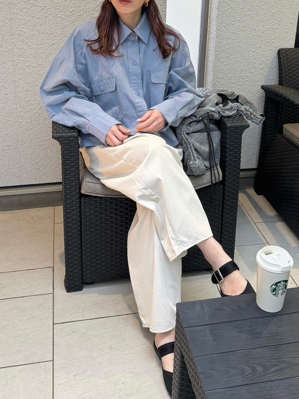 ホワイト系のチノパンツ、ブラック系のサンダル、シルバー系のトートバッグを着用したレディースの春コーディネートの3枚目の写真