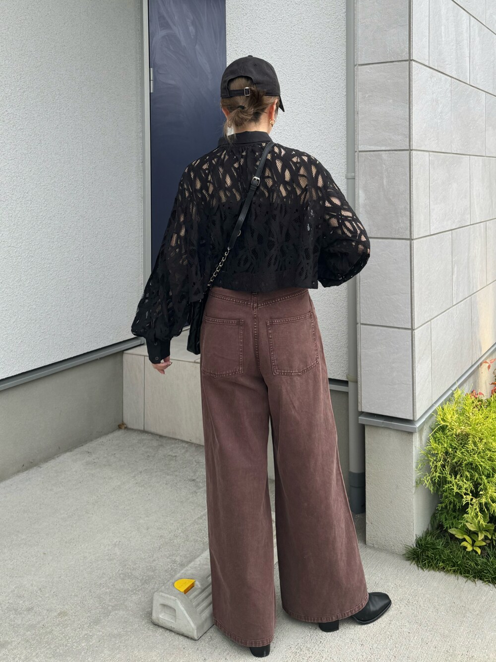 ブラウン系のデニムパンツ、ブラック系のショルダーバッグ、ブラック系のシャツ/ブラウスを着用したレディースの秋コーディネートの4枚目の写真