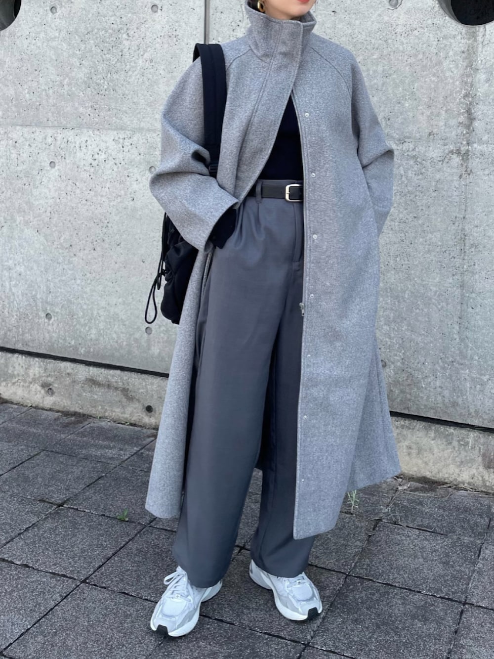 グレー系のセットアップ、グレー系のスニーカー、ブラック系のバックパック/リュックを着用したレディースの秋コーディネートの2枚目の写真