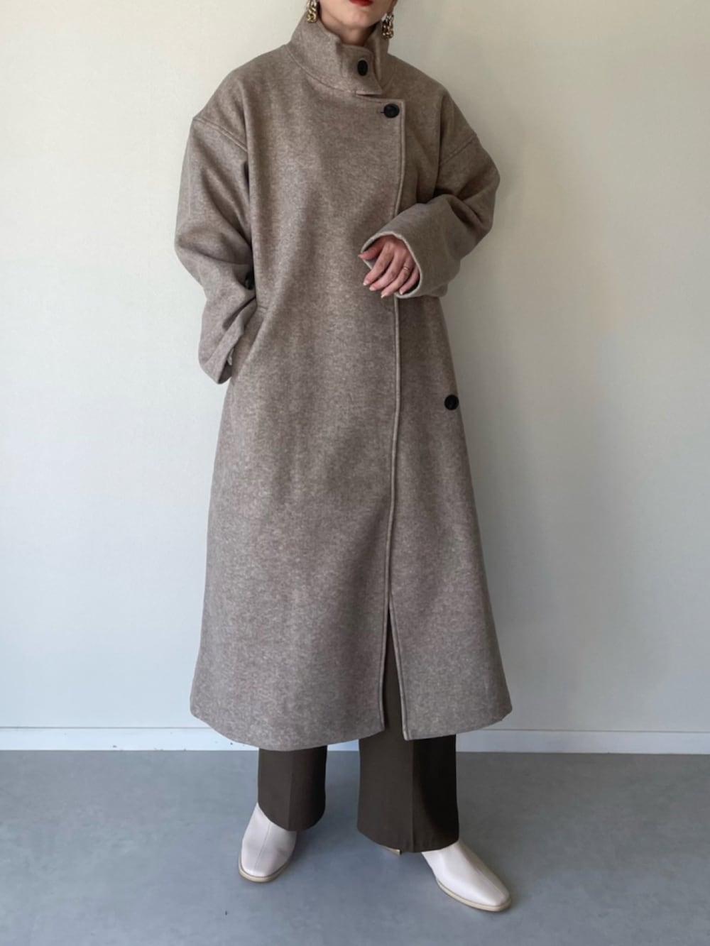 ブラウン系のその他アウター、ベージュ系のショルダーバッグ、ホワイト系のブーツを着用したレディースの秋コーディネートの2枚目の写真