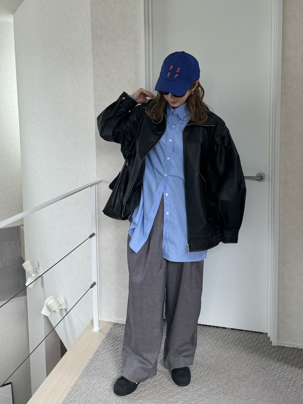 ブルー系のシャツ/ブラウス、グレー系のスラックス、ブラック系のライダースジャケットを着用したレディースの冬コーディネートの2枚目の写真