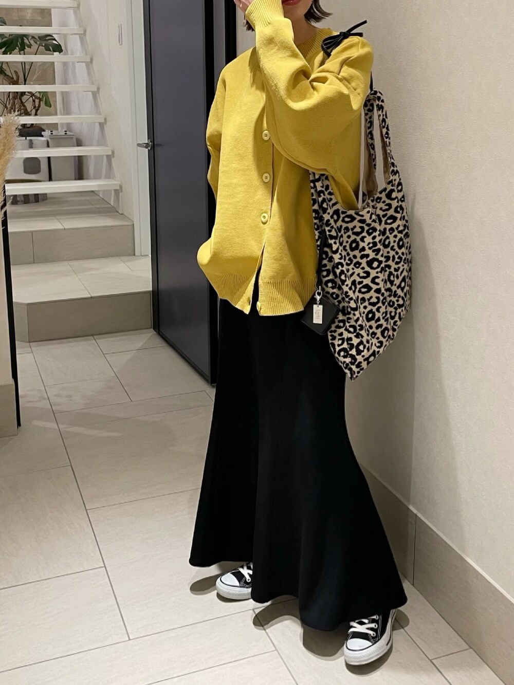 イエロー系のニット/セーター、その他のトートバッグ、ブラック系のスカートを着用したレディースの冬コーディネートの2枚目の写真