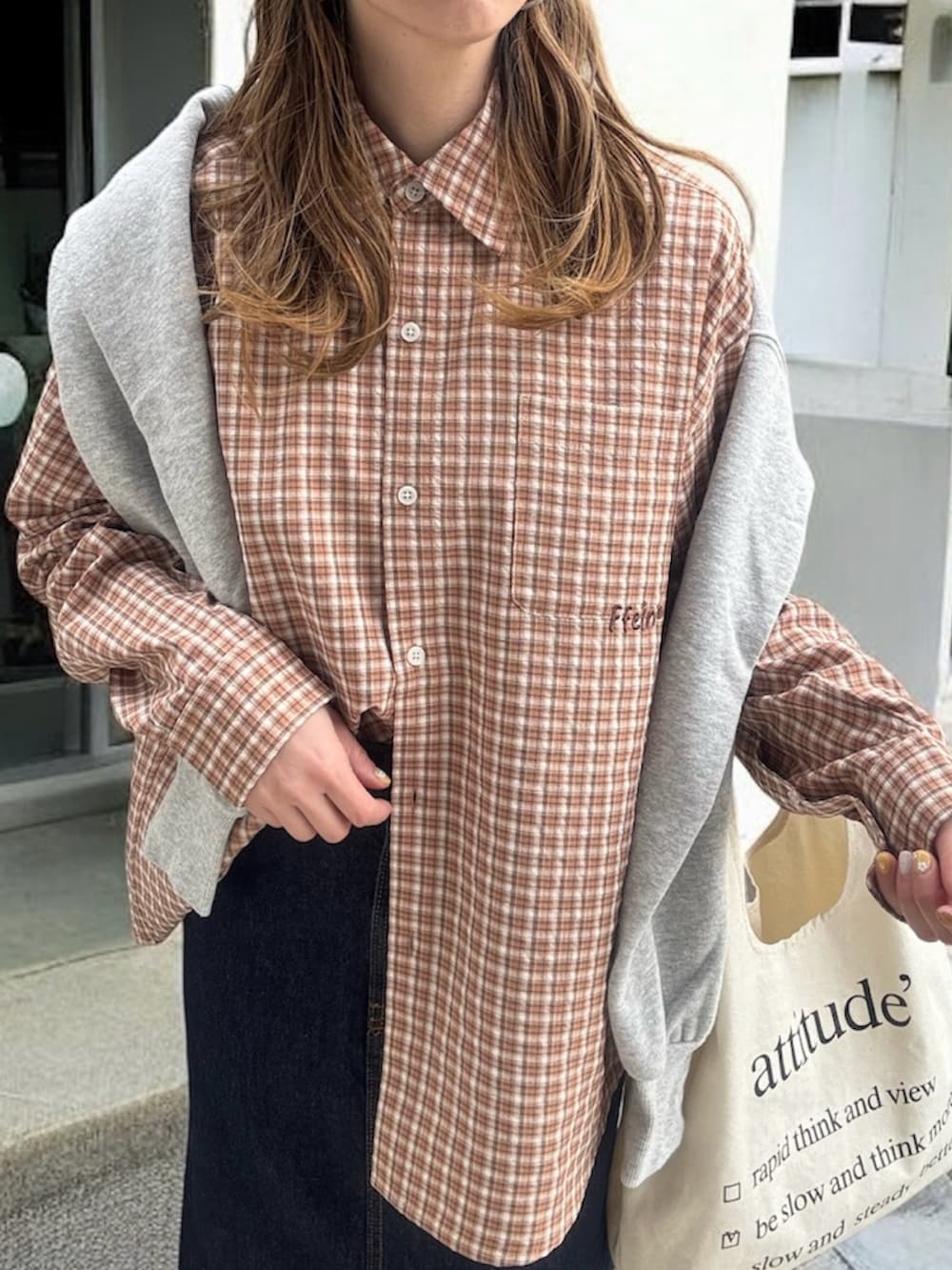 ブラウン系のシャツ/ブラウス、ブルー系のデニムスカート、ブラック系のスニーカーを着用したレディースの春コーディネートの4枚目の写真