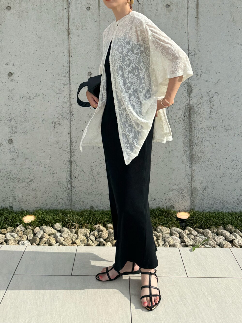 ホワイト系のシャツ/ブラウス、ブラック系のワンピース、ブラック系のサンダルを着用したレディースの夏コーディネートの2枚目の写真