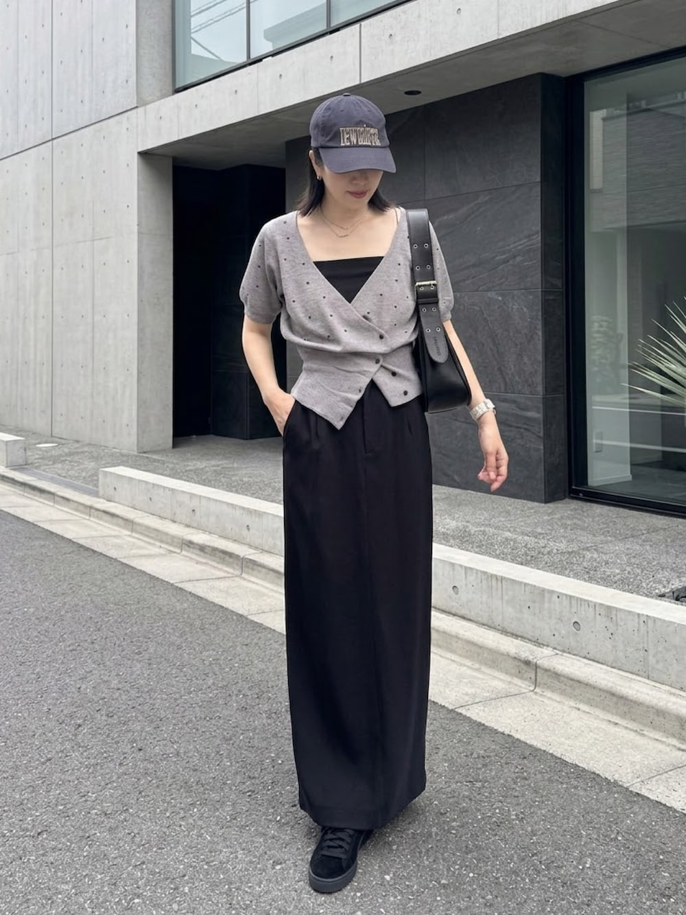 グレー系のカーディガン/ボレロ、ブラック系のハンドバッグ、ブラック系のスニーカーを着用したレディースの秋コーディネートの2枚目の写真