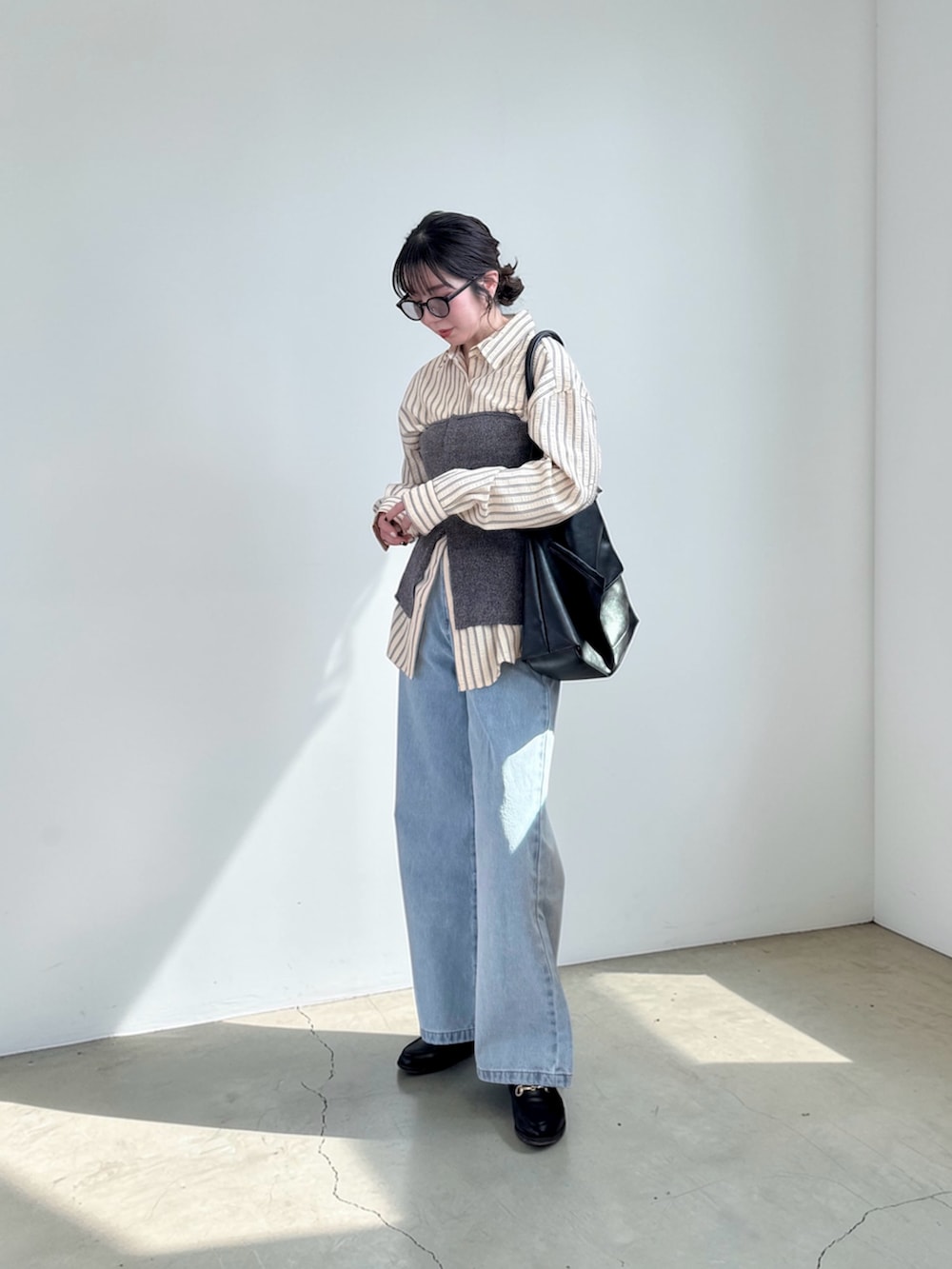 ブラック系のショルダーバッグ、イエロー系のシャツ/ブラウス、ブルー系のチューブトップを着用したレディースの春コーディネートの2枚目の写真