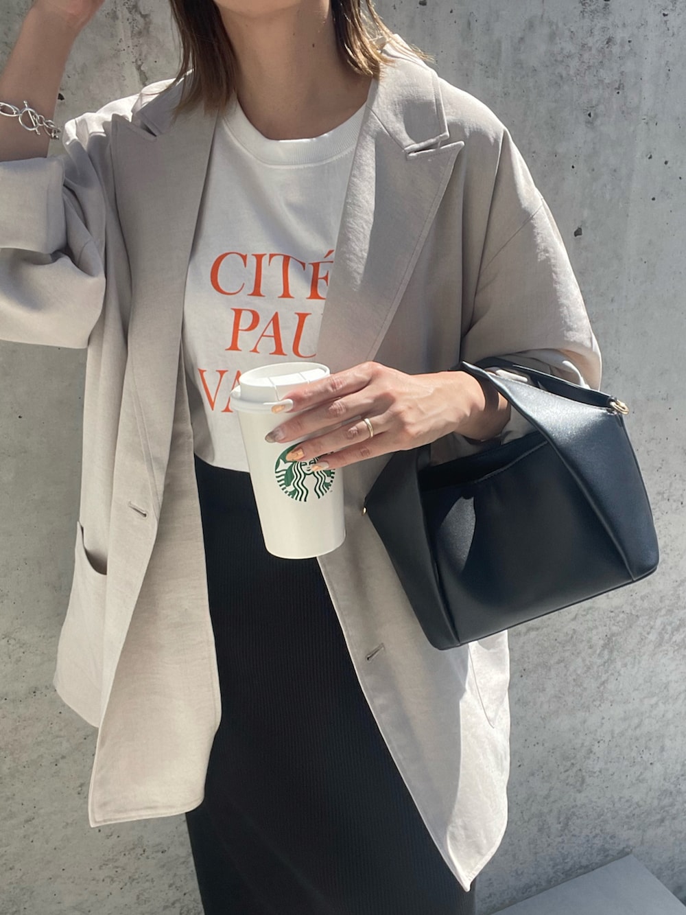 ブラック系のショルダーバッグ、オレンジ系のTシャツ/カットソー、グレー系のテーラードジャケットを着用したレディースの夏コーディネートの3枚目の写真