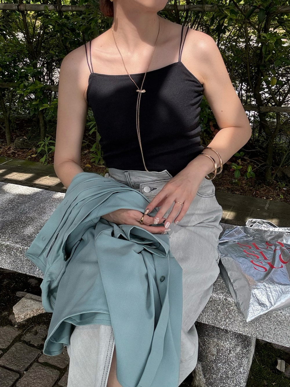 ブラック系のキャミソール、ブルー系のシャツ/ブラウス、ブラック系のサンダルを着用したレディースの春コーディネートの3枚目の写真