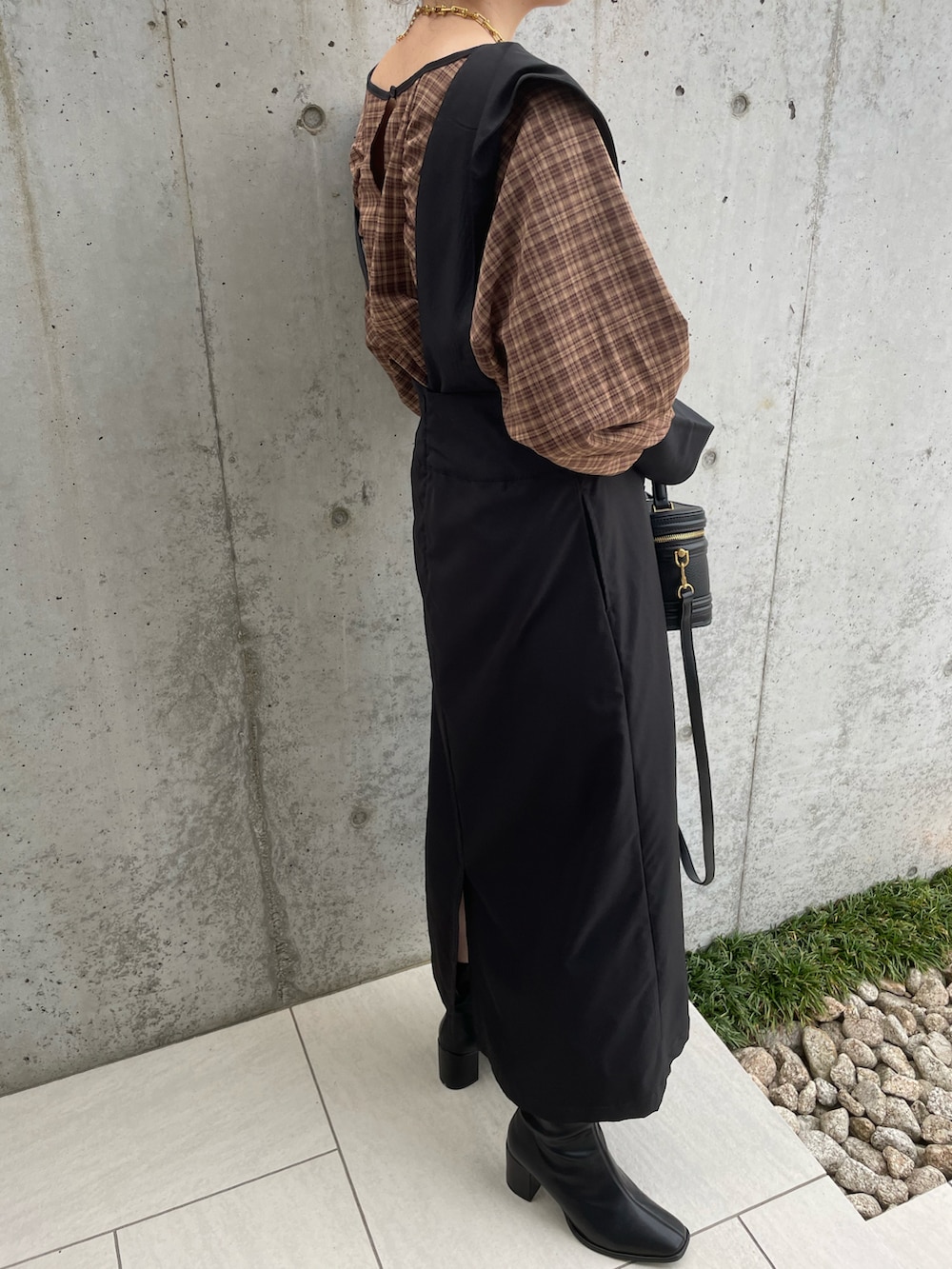 ブラック系のスカート、ベージュ系のシャツ/ブラウス、ブラック系のブーツを着用したレディースの秋コーディネートの4枚目の写真