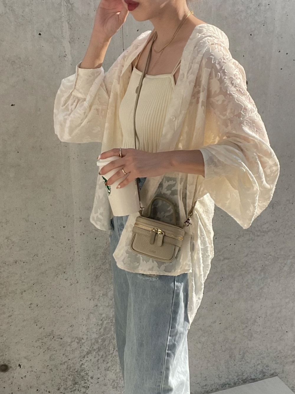 ホワイト系のシャツ/ブラウス、ブルー系のデニムパンツ、ベージュ系のショルダーバッグを着用したレディースの夏コーディネートの5枚目の写真