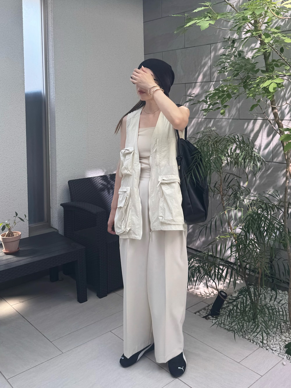 ホワイト系のベスト、ホワイト系のその他パンツ、ブラック系のスニーカーを着用したレディースの夏コーディネートの3枚目の写真