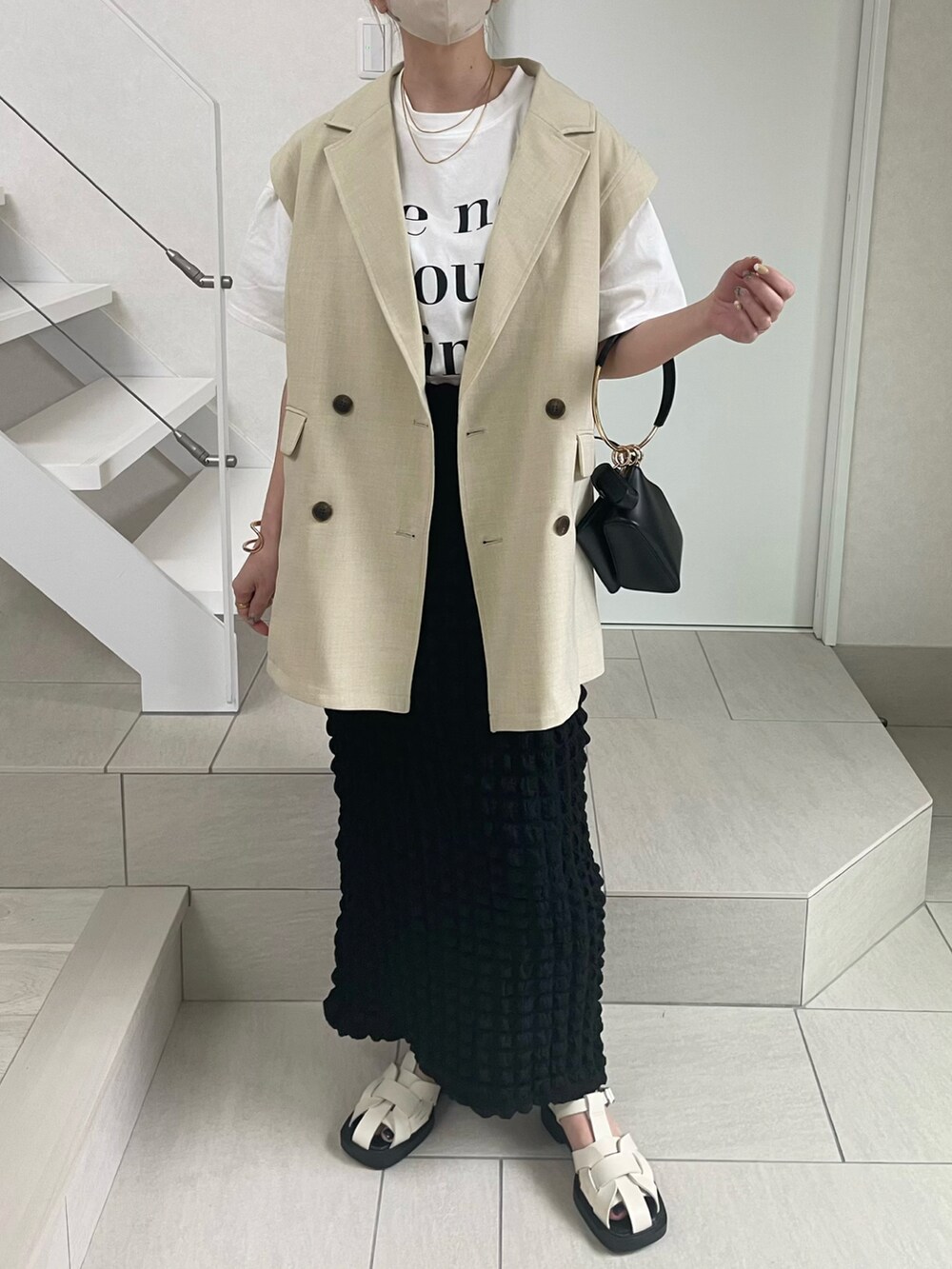 ホワイト系のTシャツ/カットソー、ホワイト系のサンダル、ホワイト系のベストを着用したレディースの春コーディネートの2枚目の写真