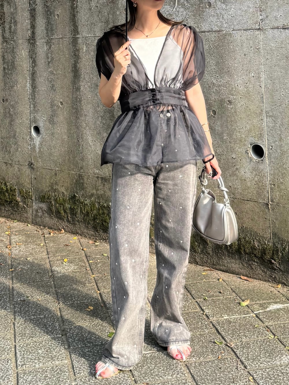 ブラック系のTシャツ/カットソー、ブラック系のデニムパンツ、シルバー系のサンダルを着用したレディースの夏コーディネートの5枚目の写真