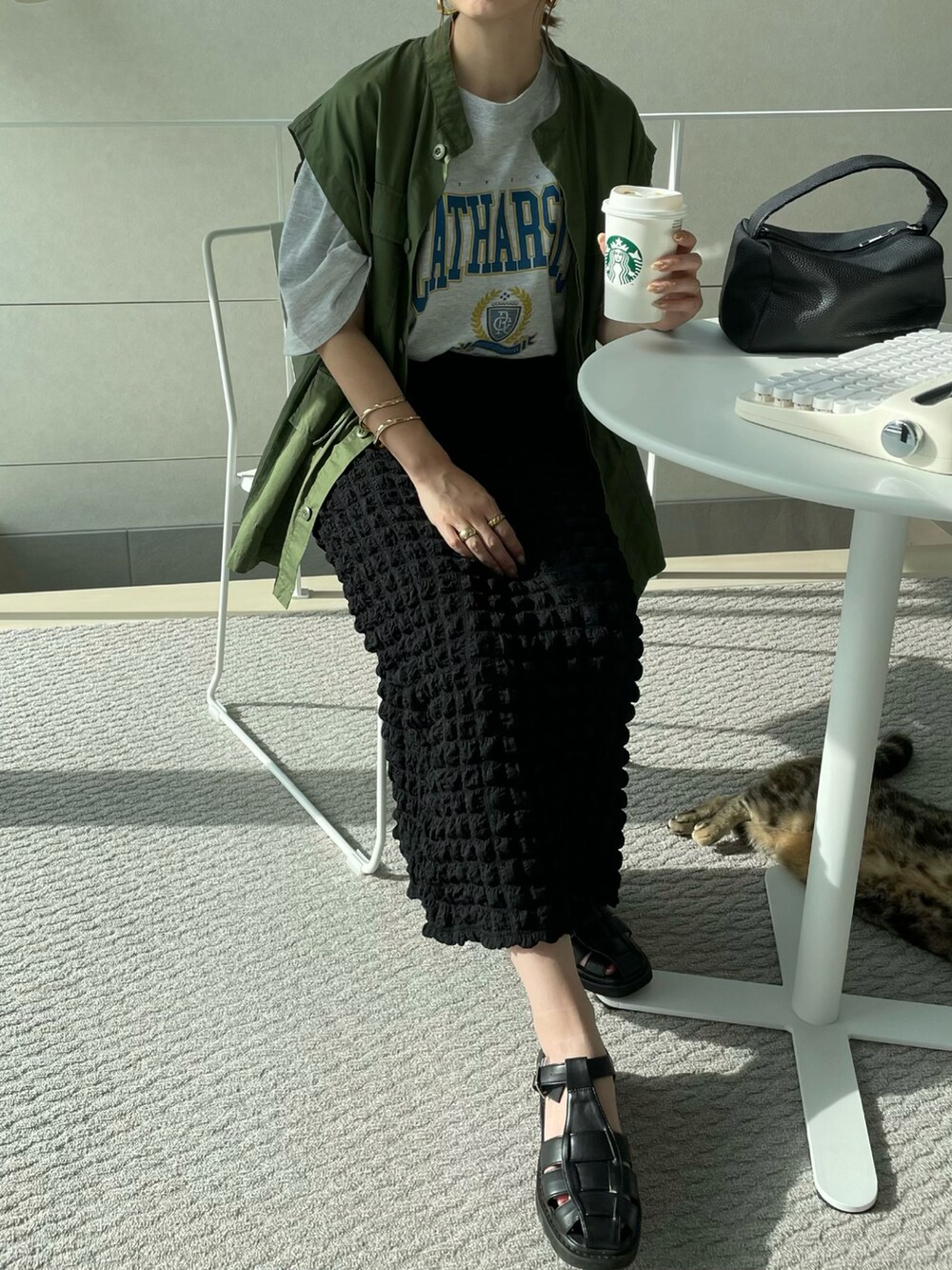 ブルー系のTシャツ/カットソー、ブラック系のスカート、グリーン系のベストを着用したレディースの夏コーディネートの2枚目の写真