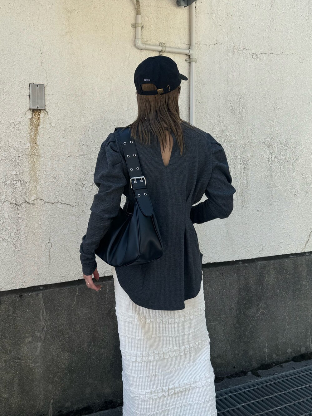 ホワイト系のスカート、グレー系のTシャツ/カットソー、ブラック系のハンドバッグを着用したレディースの秋コーディネートの4枚目の写真