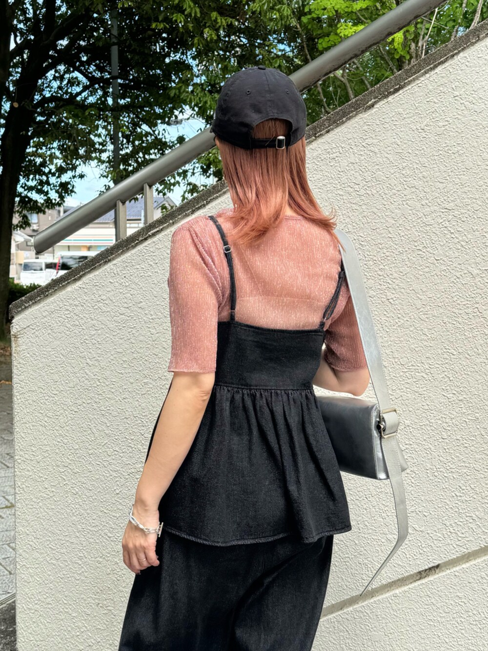 ブラック系のキャミソール、ブラック系のデニムパンツ、シルバー系のサンダルを着用したレディースの夏コーディネートの5枚目の写真