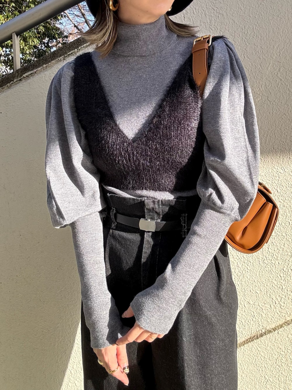 ブラック系のニット/セーター、ベージュ系のショルダーバッグ、グレー系のニット/セーターを着用したレディースの冬コーディネートの4枚目の写真