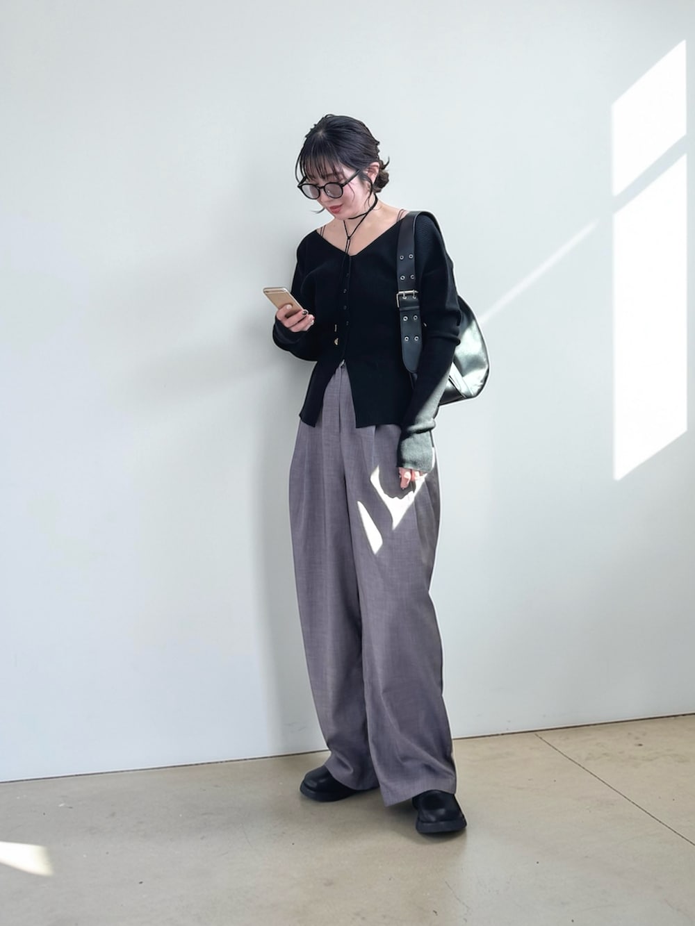 グレー系のスラックス、ブラック系のハンドバッグ、ブラック系のその他シューズを着用したレディースの春コーディネートの2枚目の写真