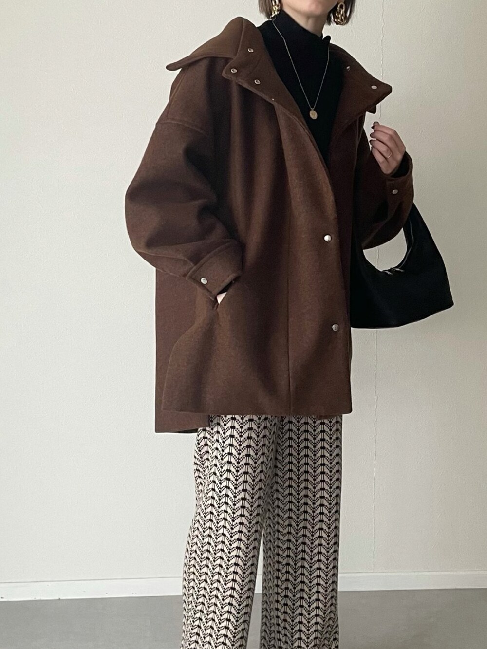 ブラック系のその他パンツ、ブラック系のニット/セーター、ブラウン系のその他アウターを着用したレディースの冬コーディネートの3枚目の写真