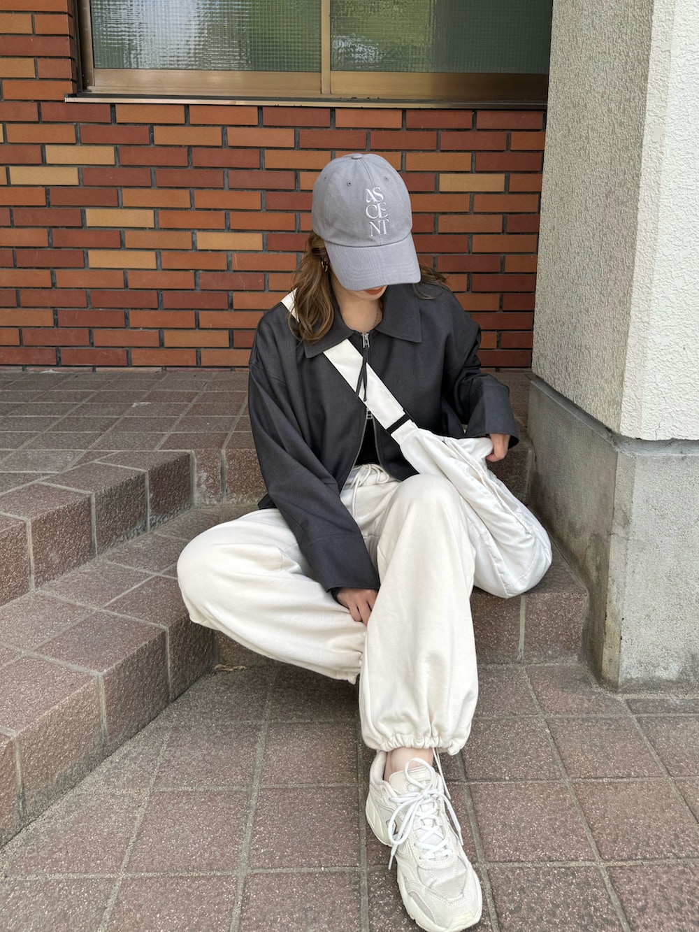 グレー系のその他アウター、ホワイト系のショルダーバッグ、グレー系のキャップを着用したレディースの秋コーディネートの3枚目の写真