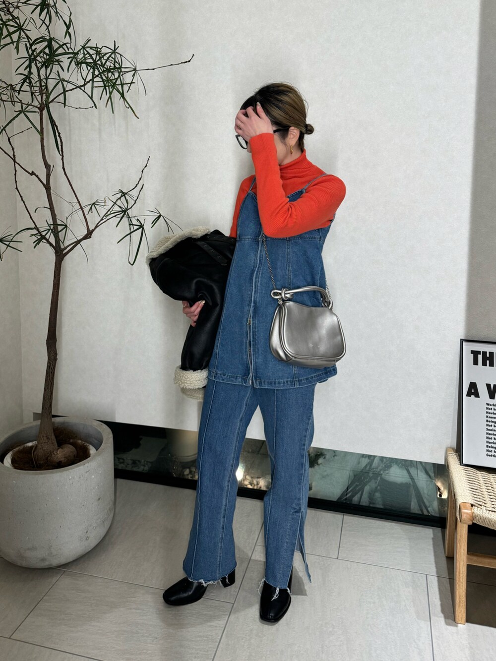 ブルー系のベスト、ブルー系のデニムパンツ、シルバー系のショルダーバッグを着用したレディースの冬コーディネートの5枚目の写真