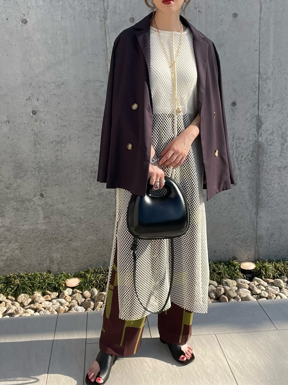 ホワイト系のベスト、ブラック系のサンダル、レッド系のその他パンツを着用したレディースの春コーディネートの3枚目の写真