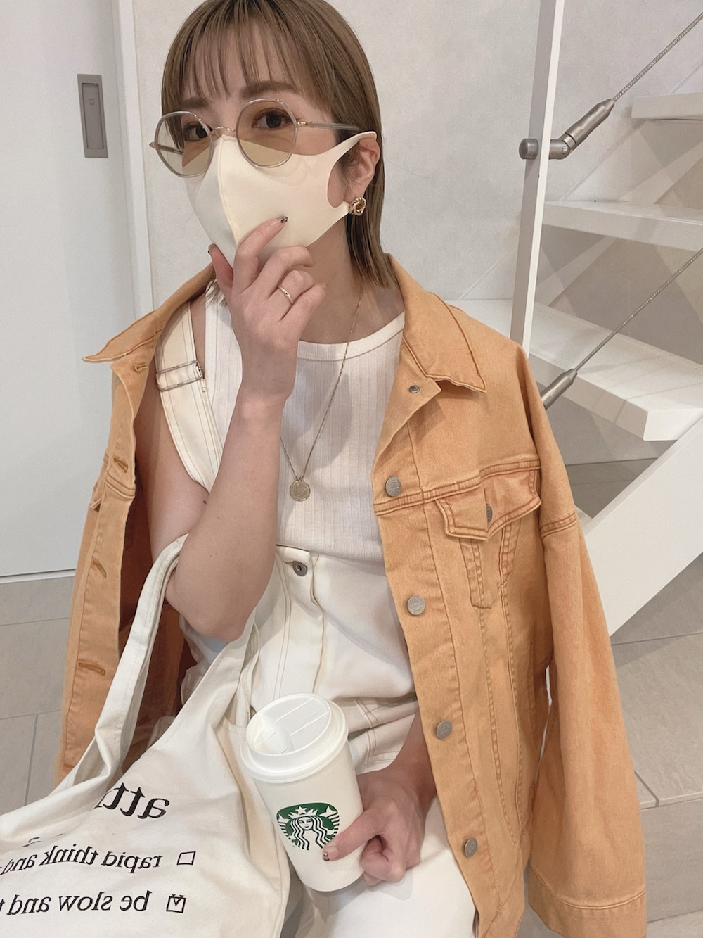 オレンジ系のデニムジャケット、ブラック系のローファー、ホワイト系のサロペット/オーバーオールを着用したレディースの春コーディネートの3枚目の写真