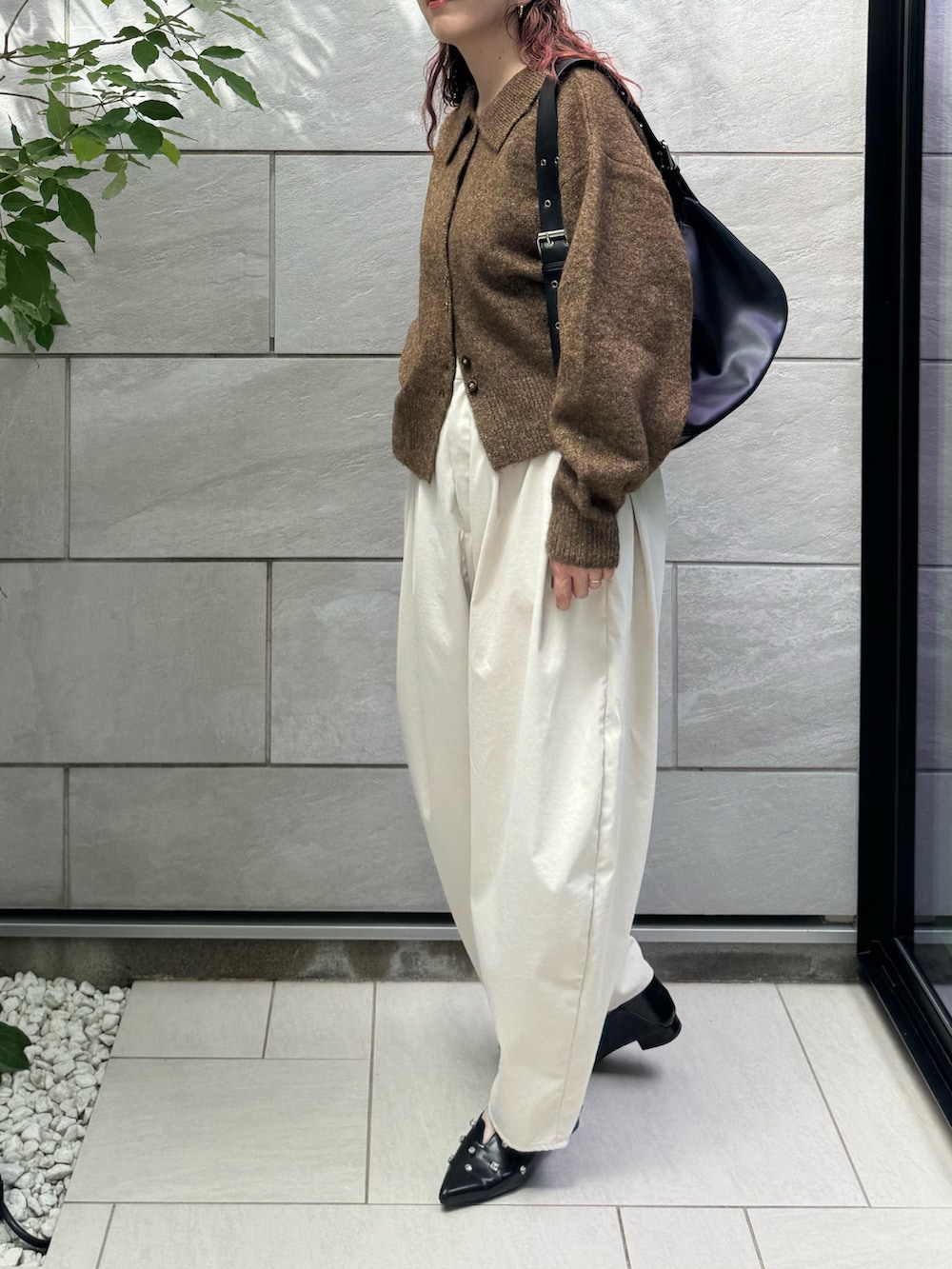 ホワイト系のチノパンツ、ブラック系のパンプス、ブラウン系のカーディガン/ボレロを着用したレディースの秋コーディネートの4枚目の写真