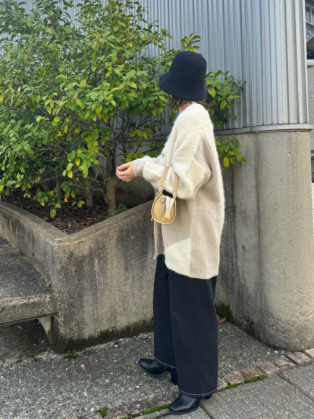 ホワイト系のカーディガン/ボレロ、ホワイト系のTシャツ/カットソー、ベージュ系のハンドバッグを着用したレディースの秋コーディネートの2枚目の写真