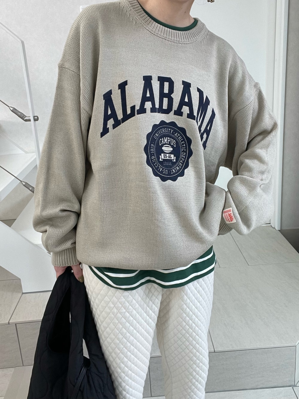 ベージュ系のニット/セーター、ホワイト系のスウェットパンツ、ブラック系のショルダーバッグを着用したレディースの冬コーディネートの3枚目の写真