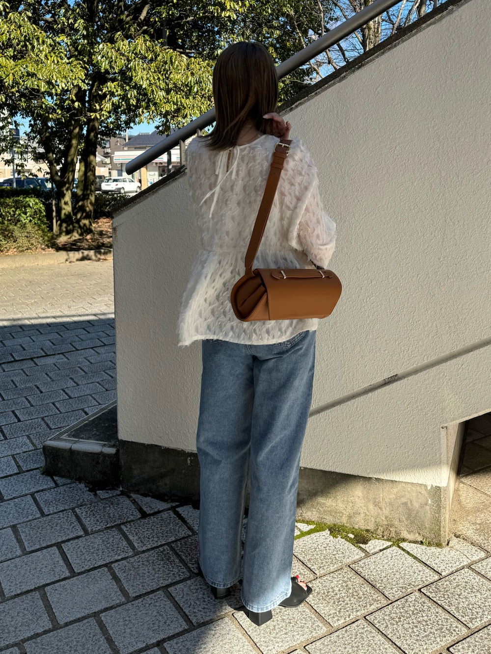 ホワイト系のシャツ/ブラウス、ブルー系のデニムパンツ、ベージュ系のショルダーバッグを着用したレディースの春コーディネートの4枚目の写真