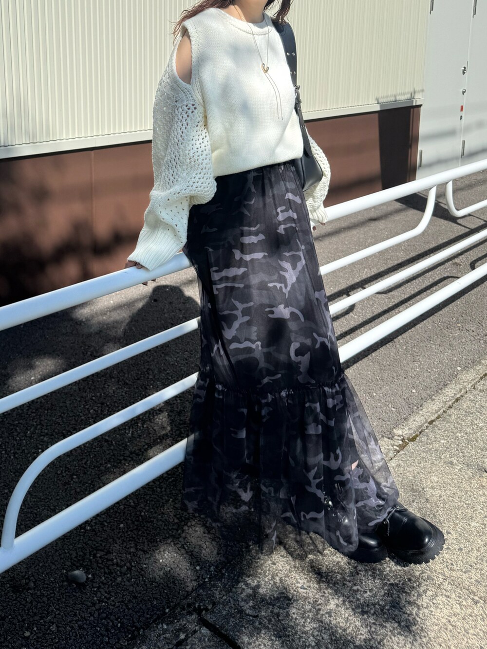 ホワイト系のニット/セーター、ブラック系のハンドバッグ、ブラック系のキャップを着用したレディースの秋コーディネートの5枚目の写真