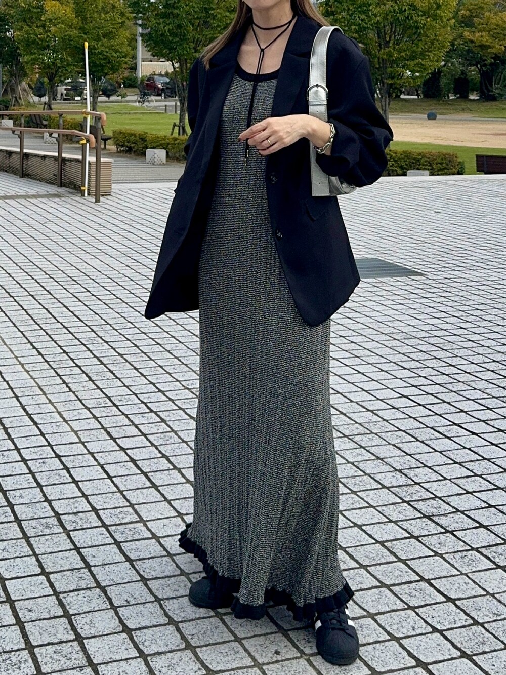 ブラック系のテーラードジャケット、ブラック系のワンピース、ブラック系のスニーカーを着用したレディースの秋コーディネートの5枚目の写真