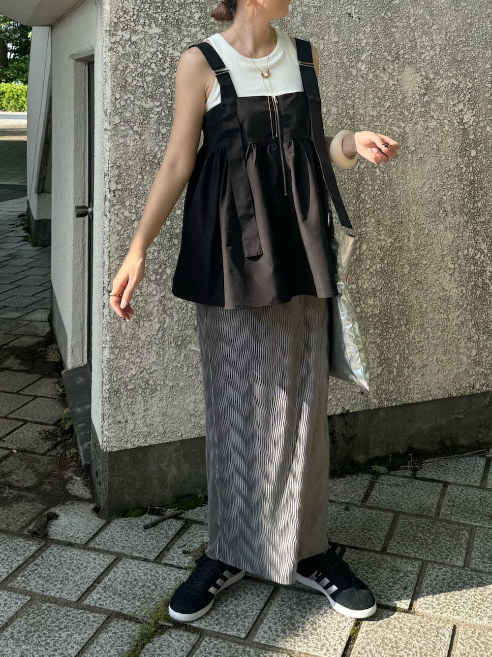 グレー系のスカート、ブラック系のその他トップス、シルバー系のトートバッグを着用したレディースの夏コーディネートの5枚目の写真