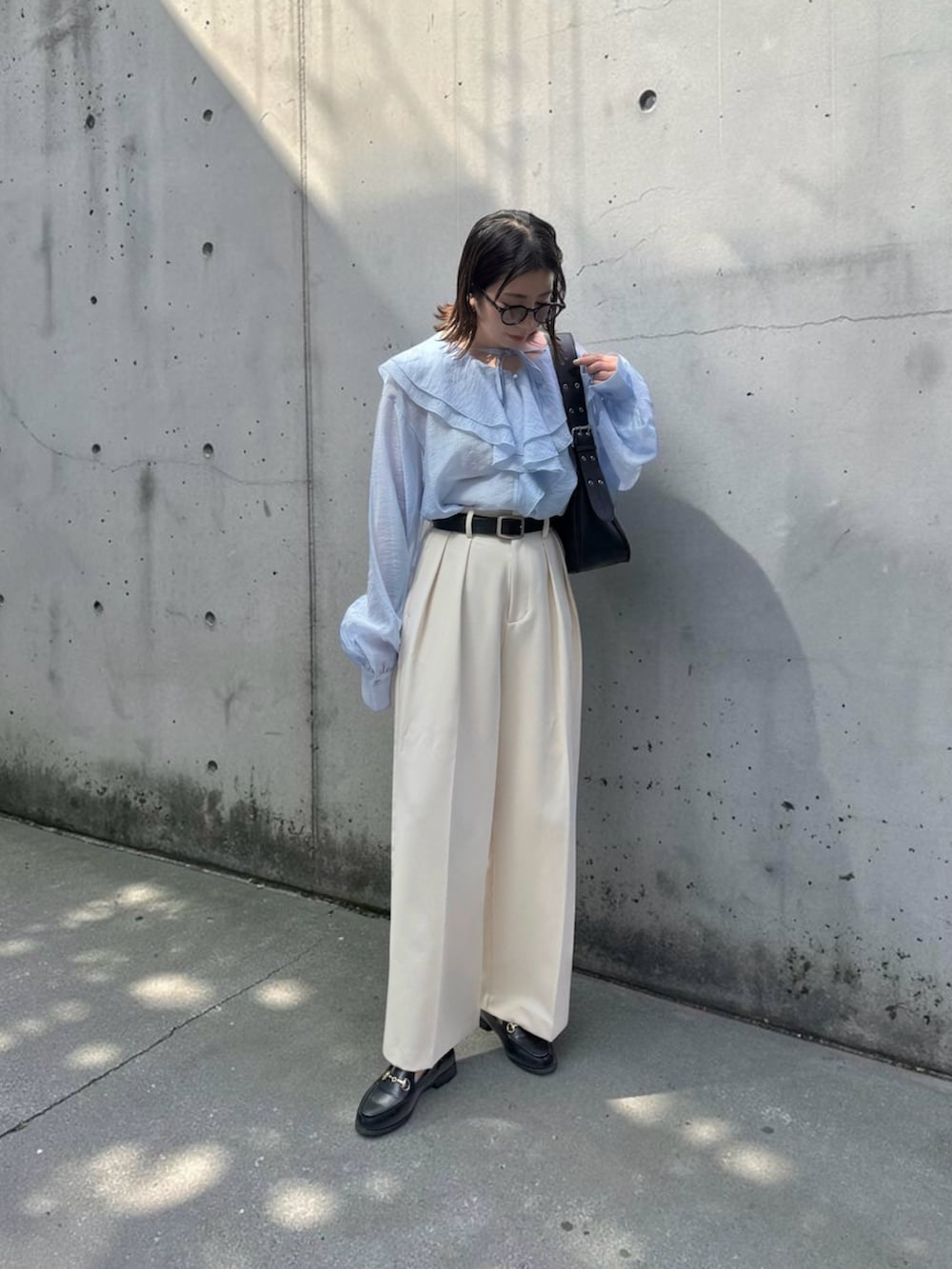 ブルー系のシャツ/ブラウス、ホワイト系のその他パンツ、ブラック系のハンドバッグを着用したレディースの春コーディネートの2枚目の写真