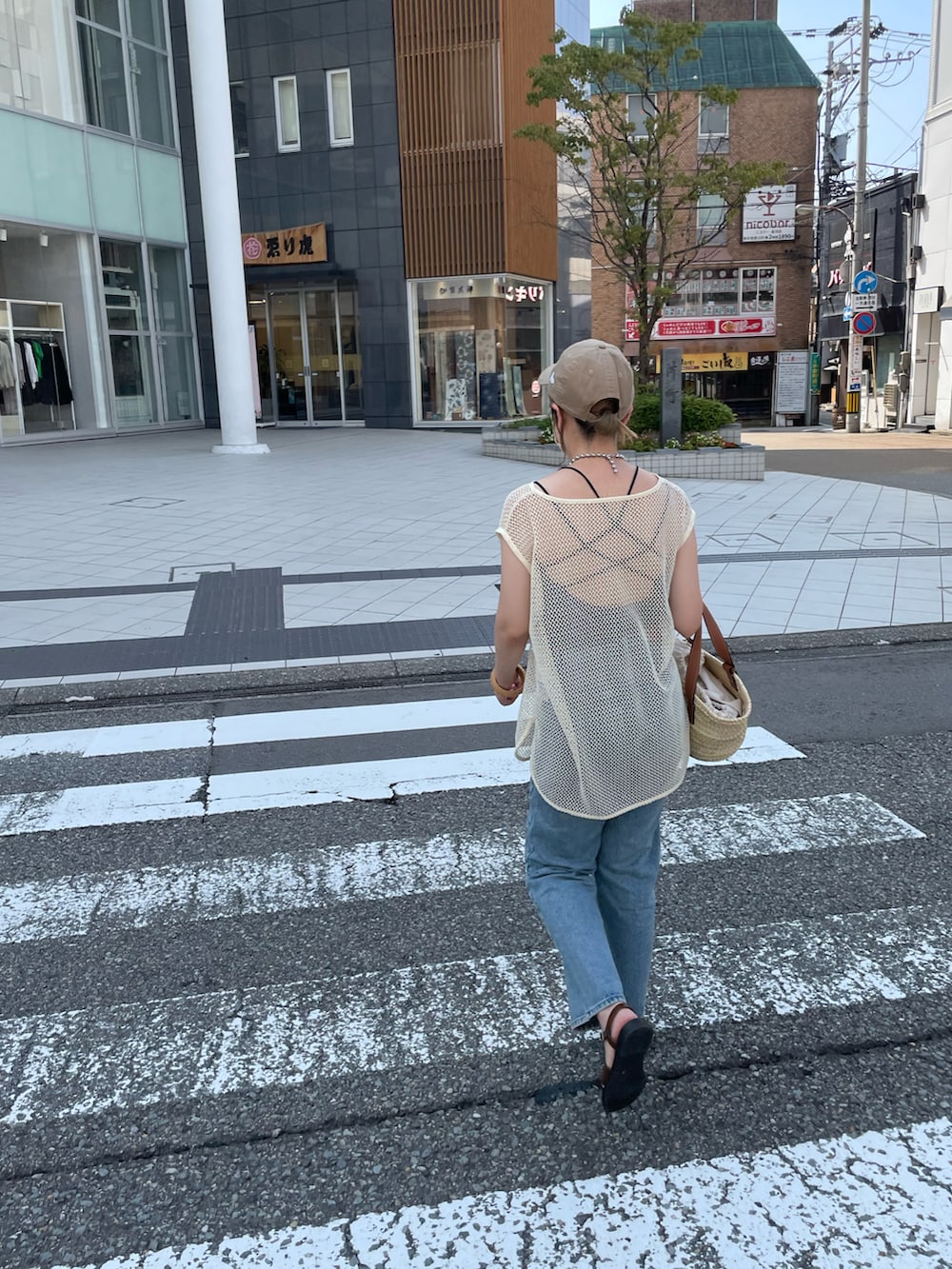 ホワイト系のTシャツ/カットソー、ブラウン系のトートバッグ、ブラウン系のサンダルを着用したレディースの夏コーディネートの2枚目の写真