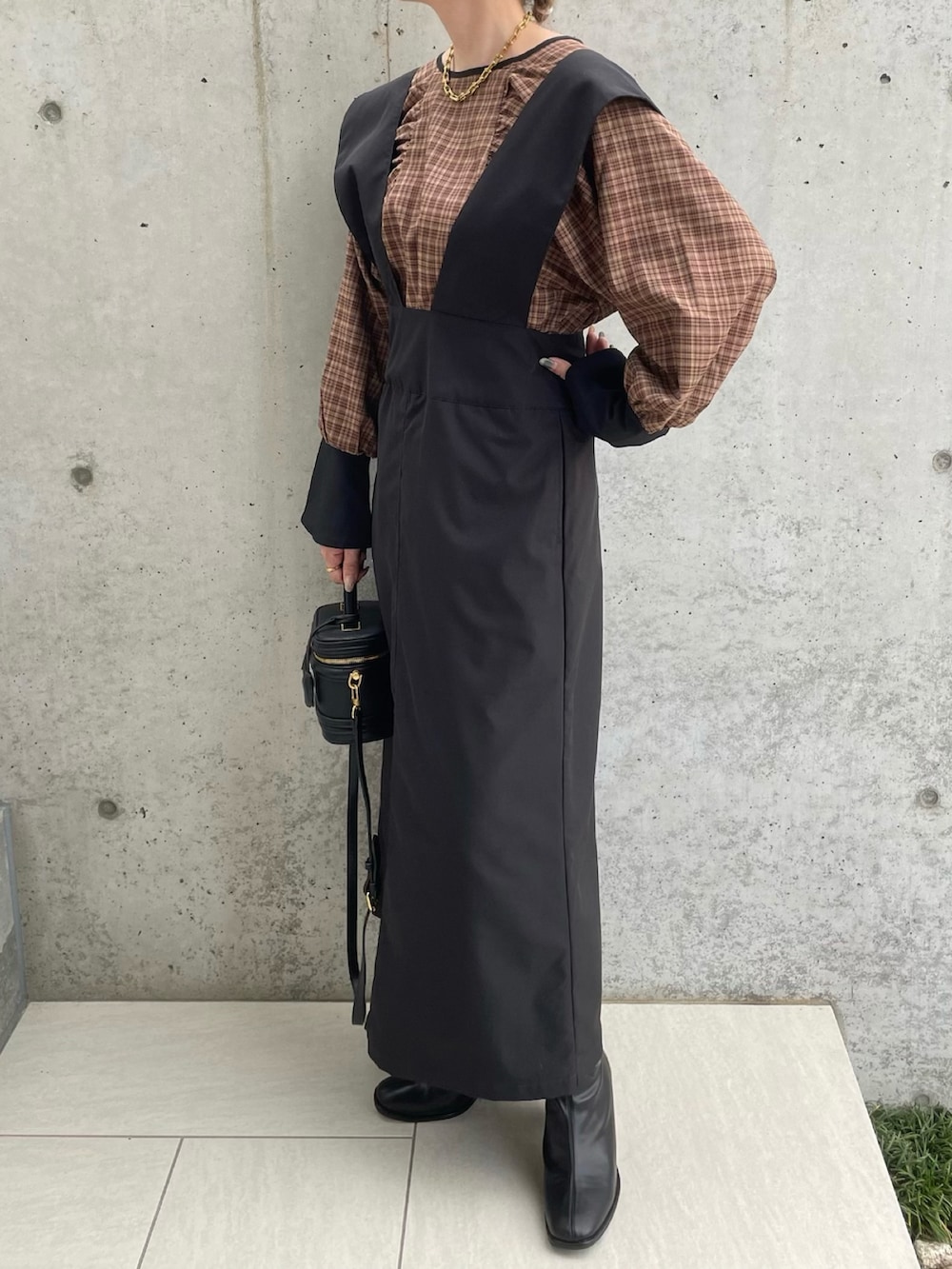 ブラック系のスカート、ベージュ系のシャツ/ブラウス、ブラック系のブーツを着用したレディースの秋コーディネートの3枚目の写真