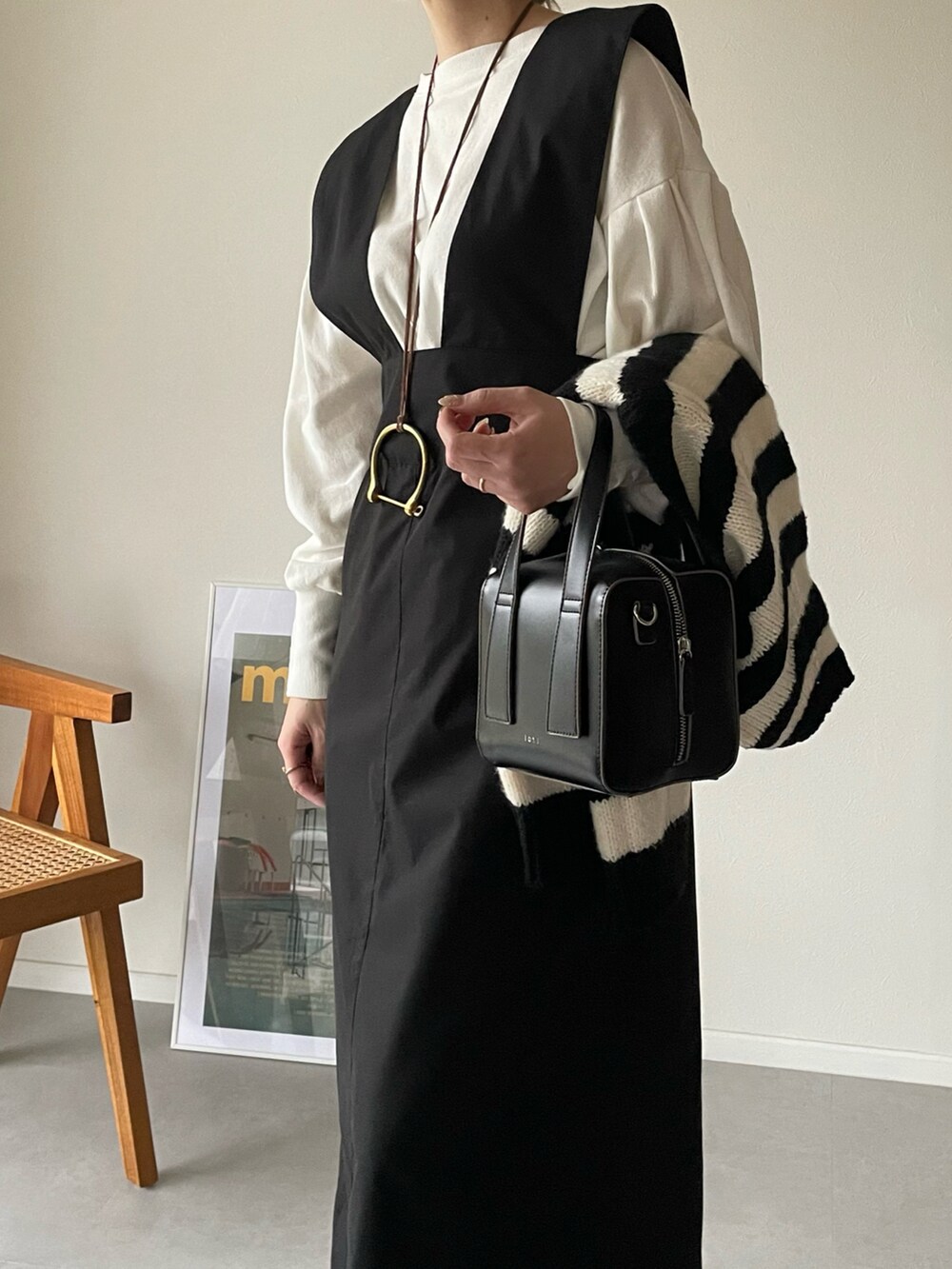 ホワイト系のTシャツ/カットソー、ブラック系のスカート、ブラック系のボストンバッグを着用したレディースの冬コーディネートの4枚目の写真