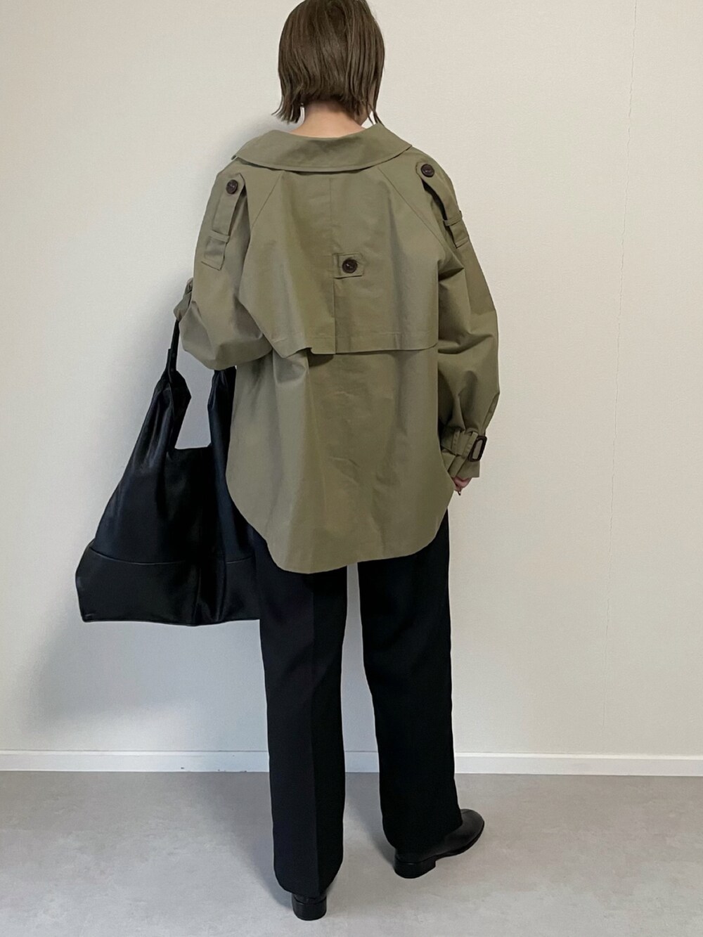 ブラック系のショルダーバッグ、グリーン系のトレンチコート、ブラック系のその他シューズを着用したレディースの冬コーディネートの3枚目の写真