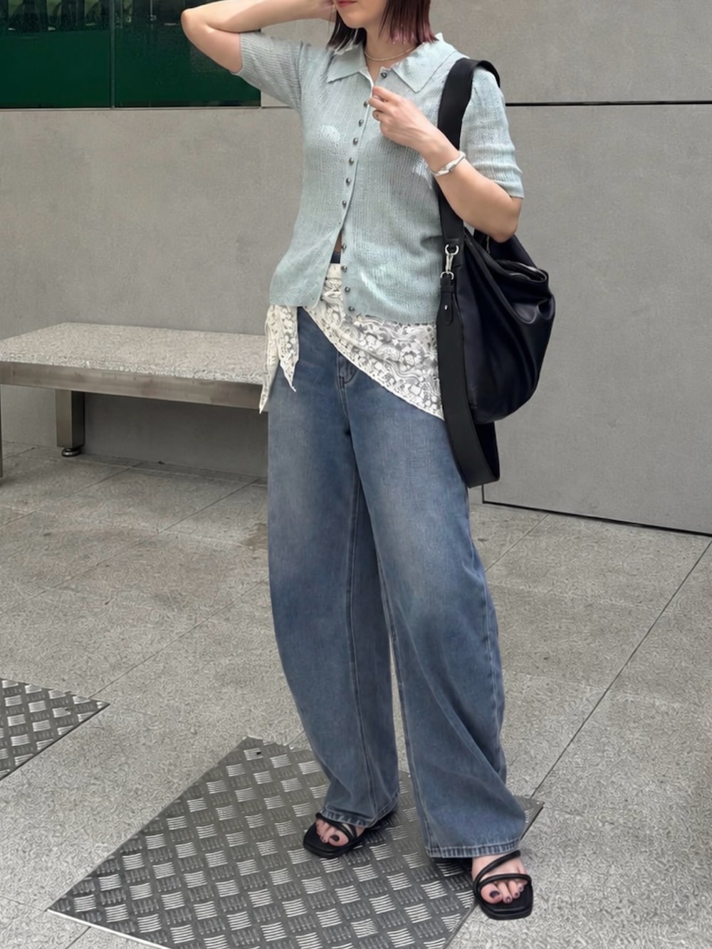 ブルー系のデニムパンツ、ブルー系のニット/セーター、ブラック系のショルダーバッグを着用したレディースの夏コーディネートの2枚目の写真