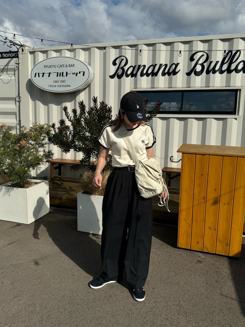 ブラック系のその他パンツ、ブラック系のスニーカー、ホワイト系のTシャツ/カットソーを着用したレディースの夏コーディネートの2枚目の写真