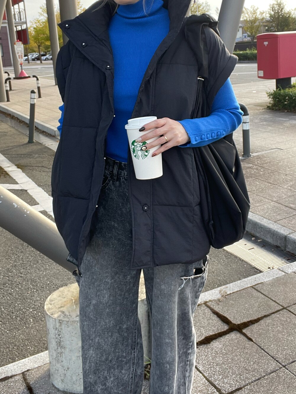 ブルー系のニット/セーター、ブラック系のデニムパンツ、ブラック系のスニーカーを着用したレディースの秋コーディネートの5枚目の写真