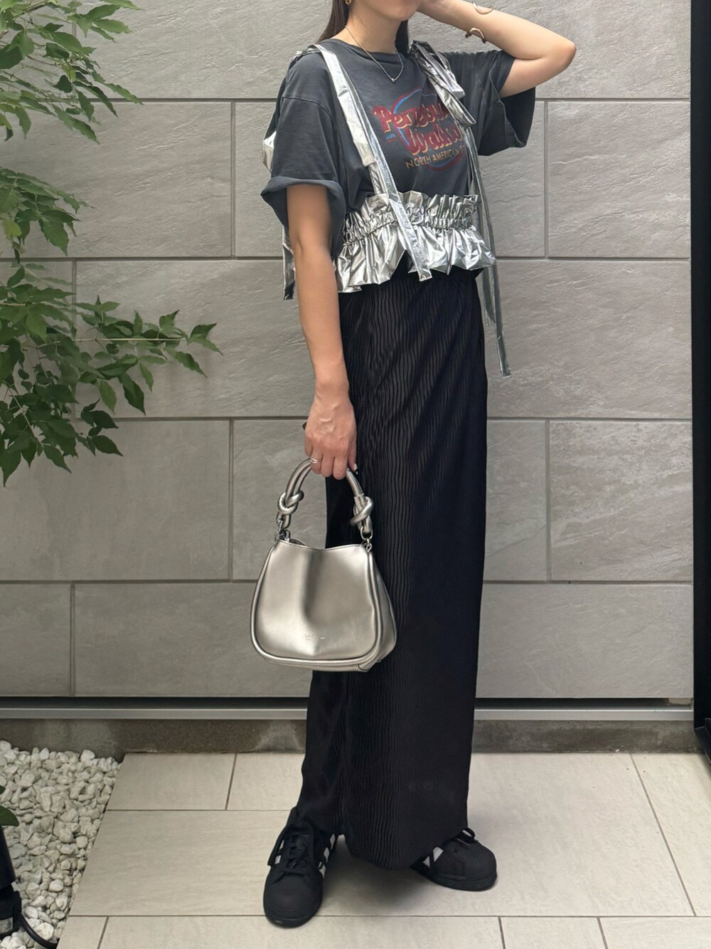 ブラック系のスカート、ブラック系のスニーカー、グレー系のTシャツ/カットソーを着用したレディースの夏コーディネートの2枚目の写真